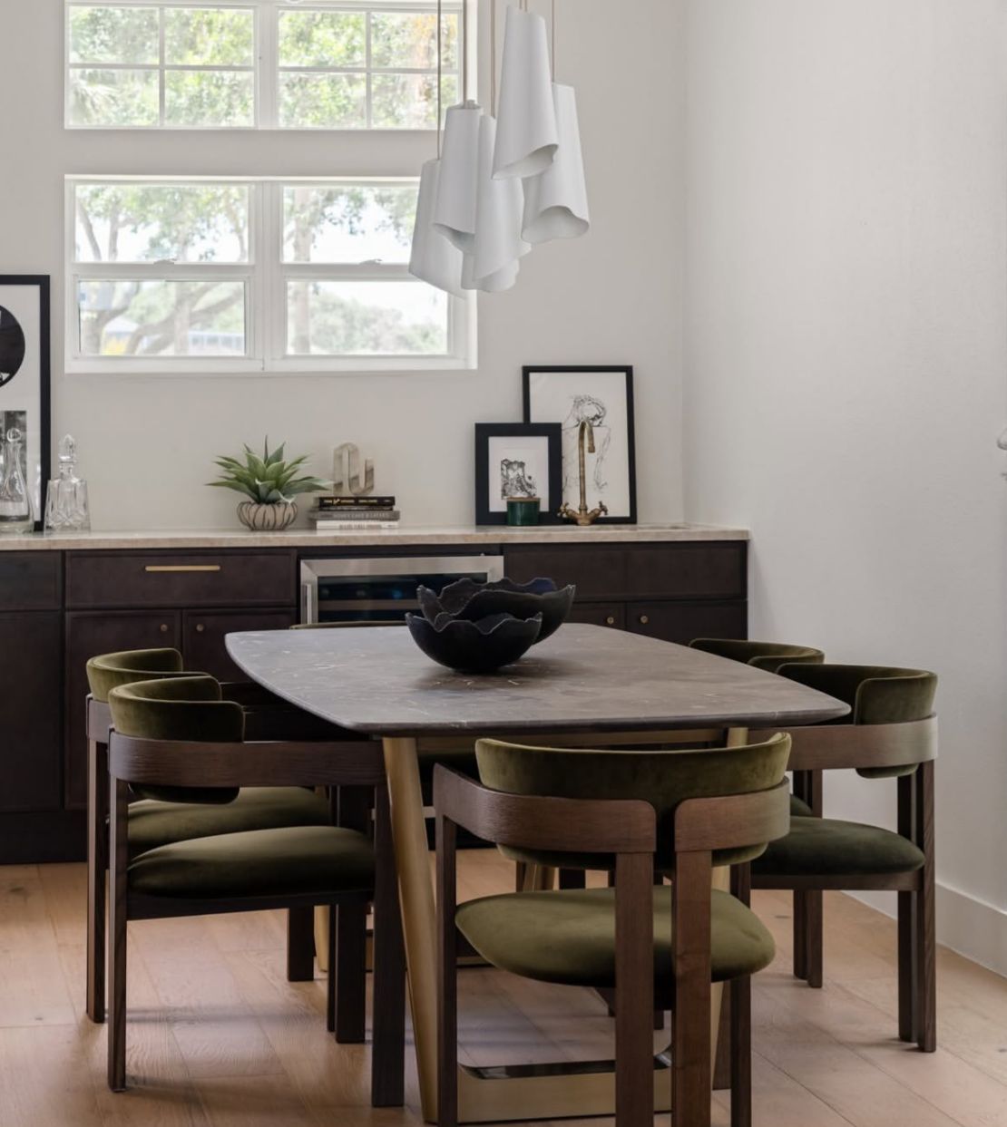Dining space with green velvet chairs and marble table
